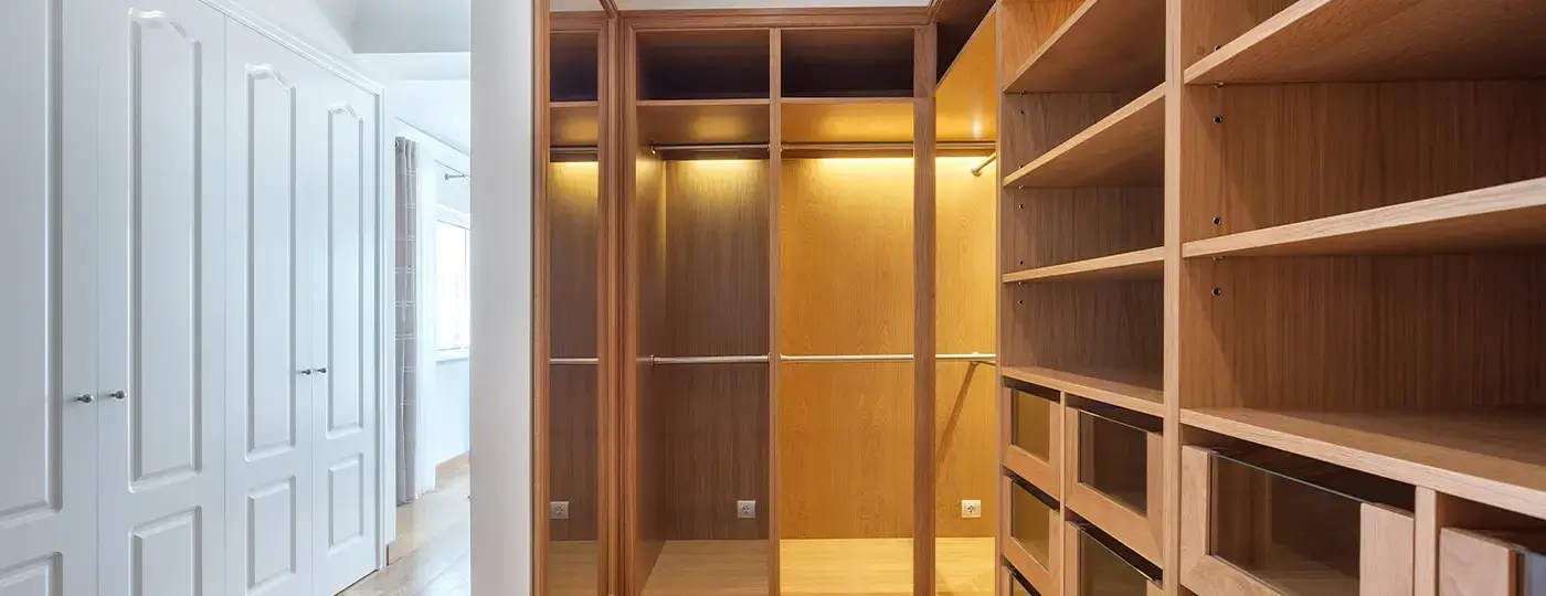 Ein moderner, offener und maßgefertigter begehbarer Kleiderschrank in heller Holzoptik.