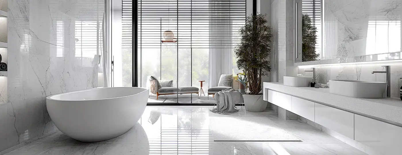 Ein modernes, helles Badezimmer mit Marmorboden, einer ovalen, freistehenden Badewanne und einer Glaswand zur Terrasse hin.