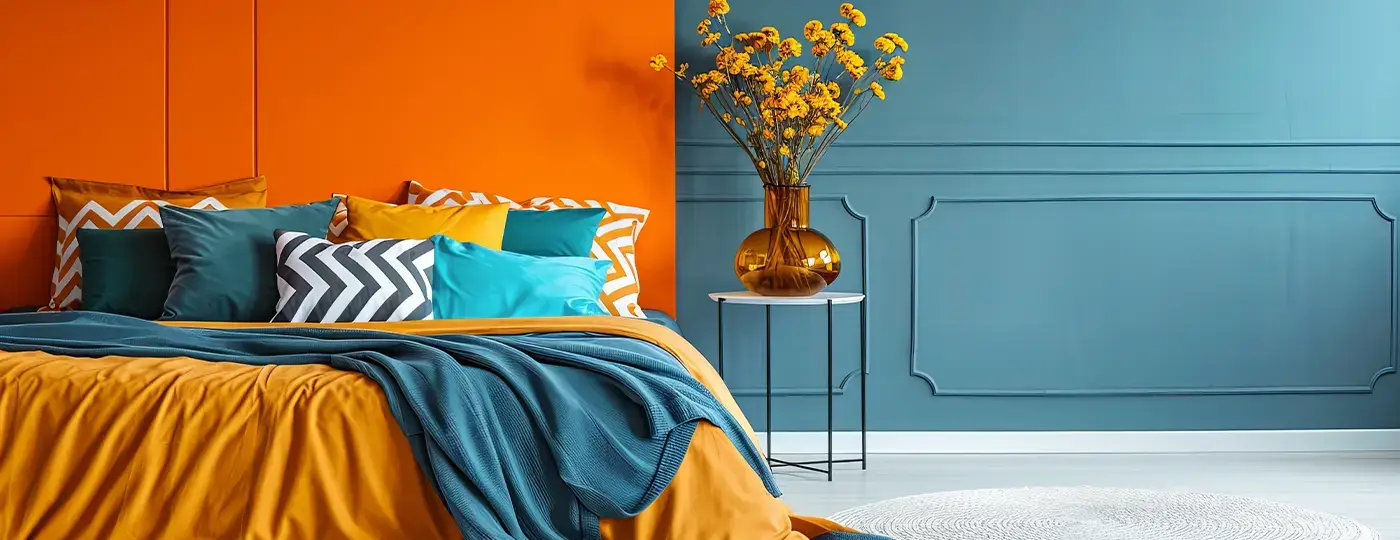 Ein Schlafzimmer mit einem Bett, das vor einer orangefarbenen Wand und einer meerblauen Wand mit Zierleisten steht.