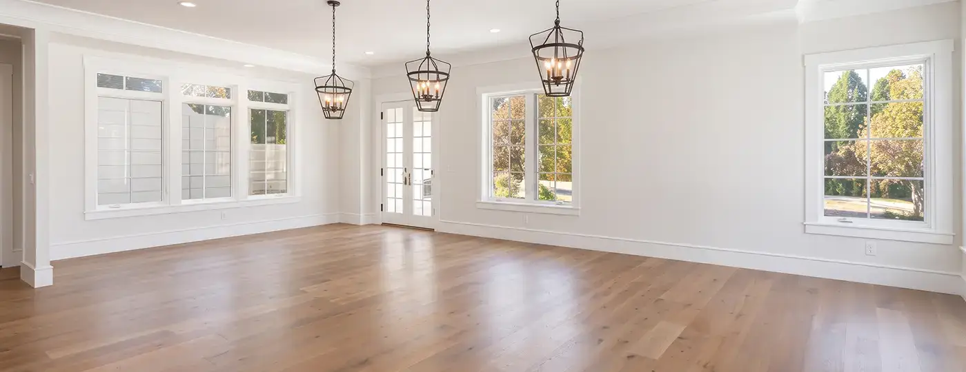 Großes, helles Wohnzimmer mit Holzboden und Hängeleuchten.