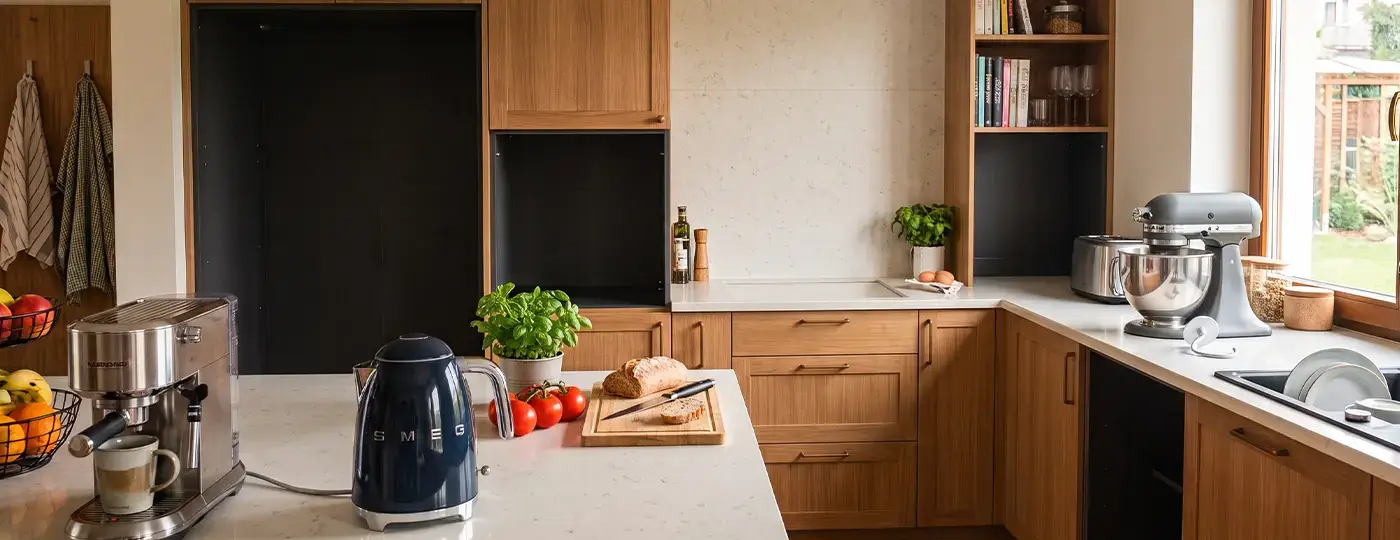 Küchenzeile aus Holz mit freien Nischen für Haushaltsgeräte sowie Kleingeräten auf der Arbeitsplatte.