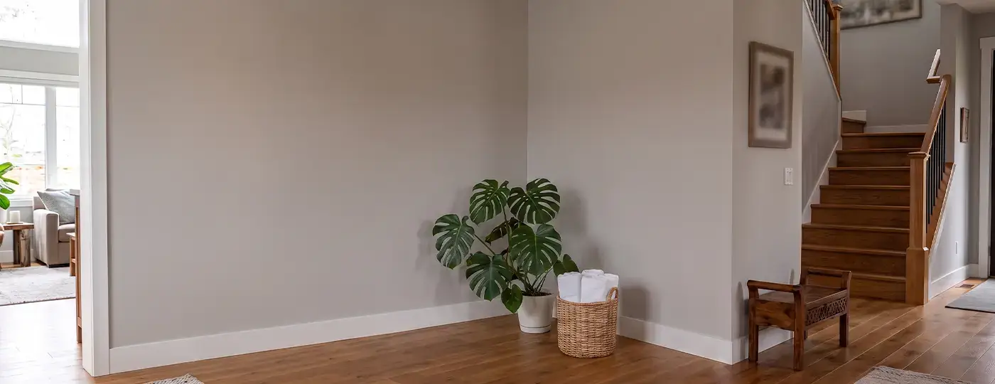 Leere Ecke mit grauen Wänden und Holzboden, vorbereitet für die Montage einer Infrarotsauna.