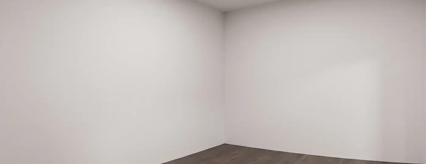 Ein leerer Raum mit weißen Wänden und dunklem Boden, vorbereitet als Gaming-Zimmer.
