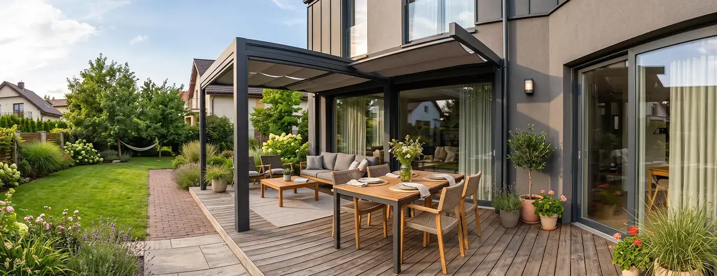 Modernes Haus mit überdachter Holzterrasse und Gartenmöbeln.