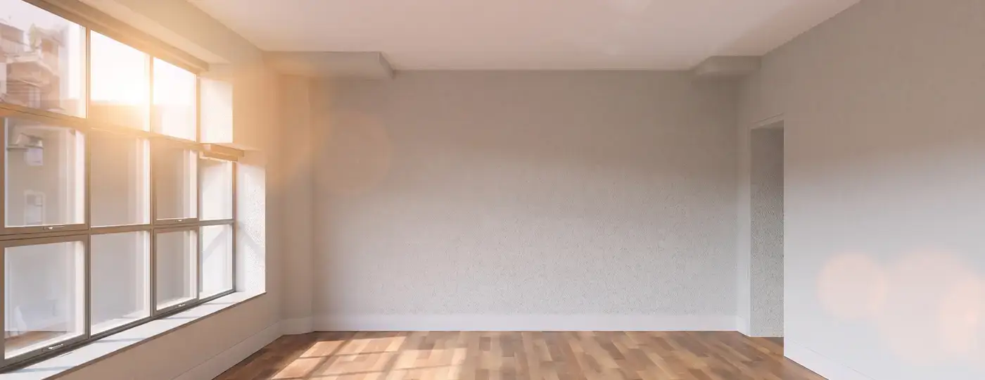 Heller, leerer Raum mit großer Fensterfront und Holzparkett.
